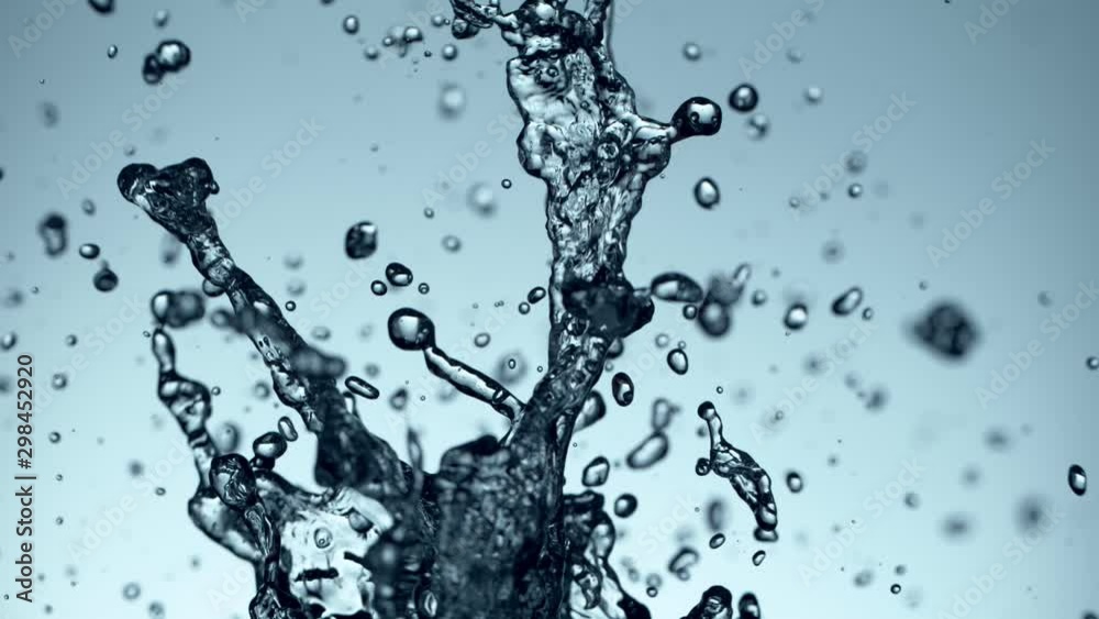 Super slow motion of flying water splash on soft blue background. Filmed on high speed cinema camera, 1000fps.