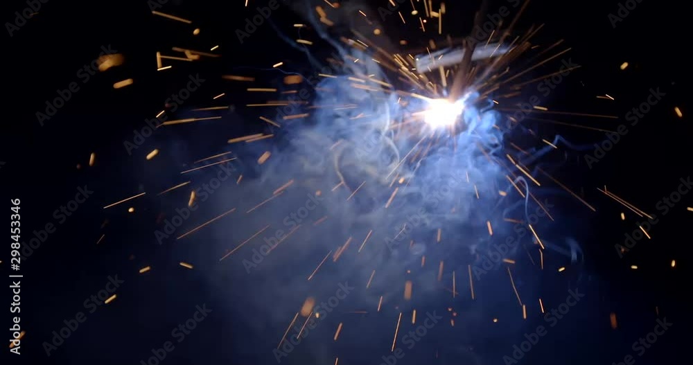 Male hand cuts off pieces of water pipe with angle grinder. Cutting of a steel with splashes of sparks at construction site. Sparks during cutting of metal angle grinder