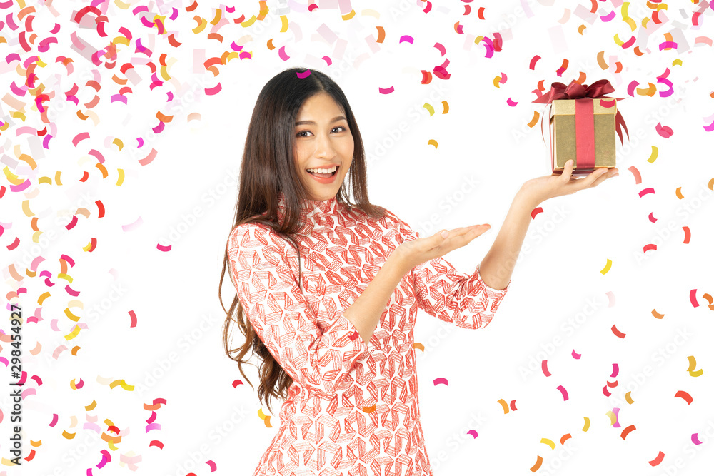Photo of asian curious woman in red dress rejoicing her birthday or new year gift box. Young woman holding gift box with red bow being excited and surprised holiday present isolated white background Photo of asian curious woman in red dress rejoicing her birthday or new year gift box. Young woman holding gift box with red bow being excited and surprised holiday present isolated white background