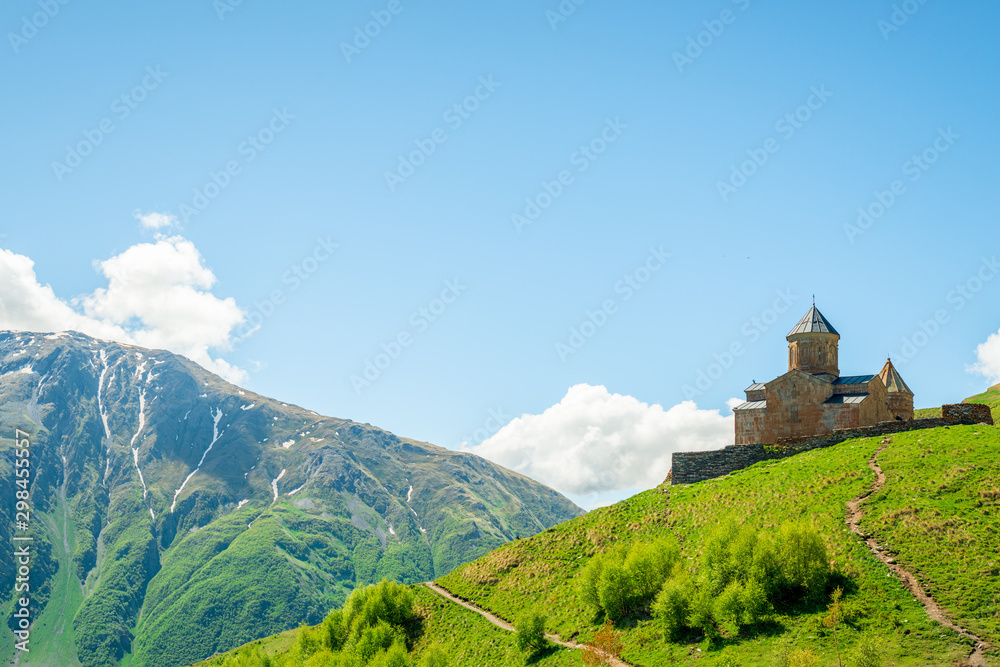 The Caucasus Mountains and the Trinity Church on a mountain in Georgia are a beautiful landmark in the village of Gergeti