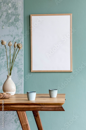 Stylish scandinavian dining room interior with mock up poster frame, wooden table, furniture, cups of coffee, flowers in vase and elegant accessories. Ready to use. Template. Modern home decor. photo