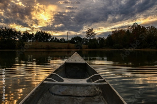 Point of view of a canoeist paddling on a serene country pond at sunset © Jennifer