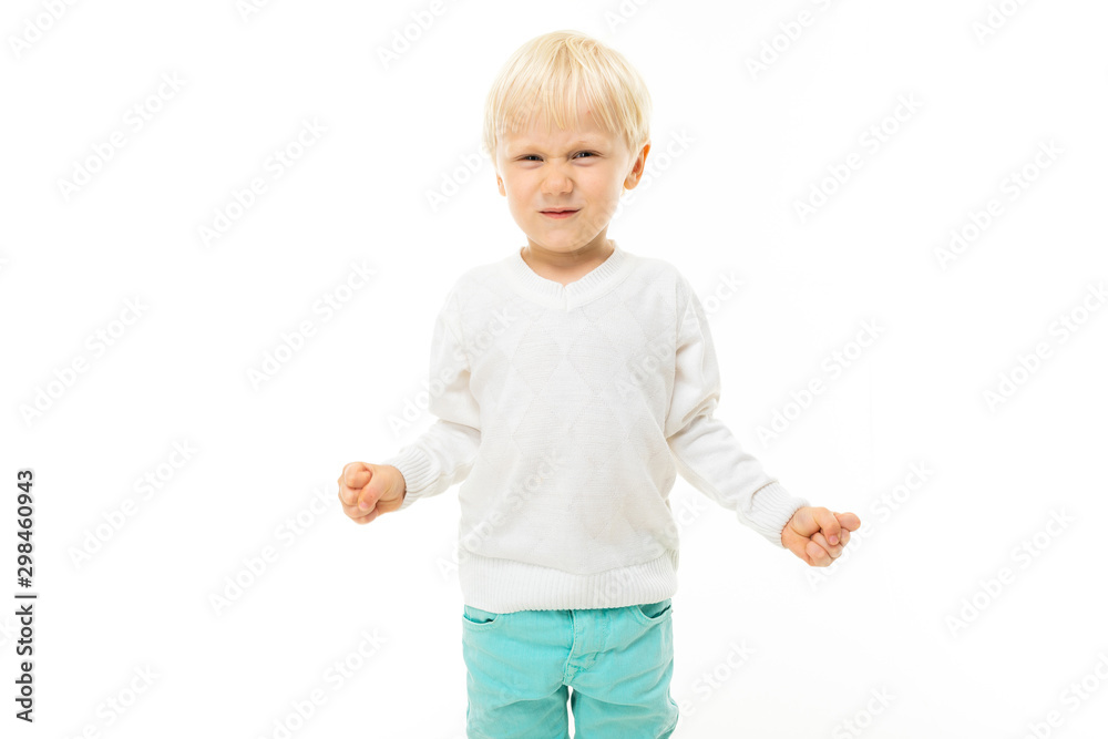 Little boy with short blonde hair, blue eyes, cute appearance, in white jacket, light blue pants, standing and smiling Little boy with short blonde hair, blue eyes, cute appearance, in white jacket, light blue pants, standing and smiling