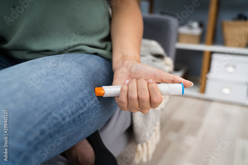 Woman Injecting Epinephrine Using Auto-injector Syringe photo