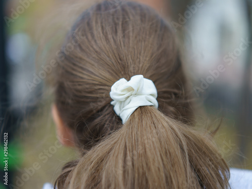 Modern Teen Hairstyle. Youth fashion. The girl putting her hair back in a ponytail.