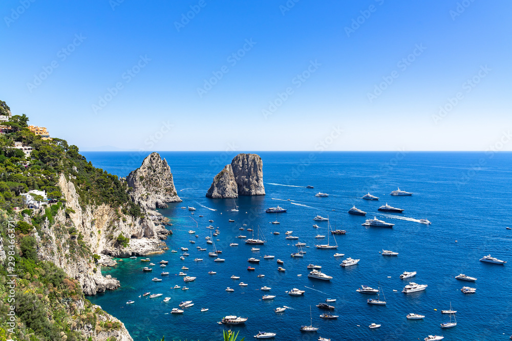 Wide panoramic view from Gardens of Augustus with the Faraglioni and blue sea full of boats and yachts, Italy