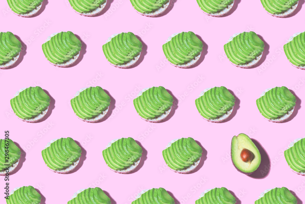 Avocado toast with avocado slice pattern on pink background. Food pattern with sunlight. Healthy food minimal concept Avocado toast with avocado slice pattern on pink background. Food pattern with sunlight. Healthy food minimal concept