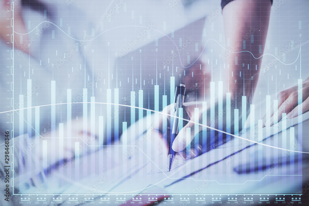 A woman hands writing information about stock market in notepad. Forex chart holograms in front. Concept of research. Double exposure A woman hands writing information about stock market in notepad. Forex chart holograms in front. Concept of research. Double exposure