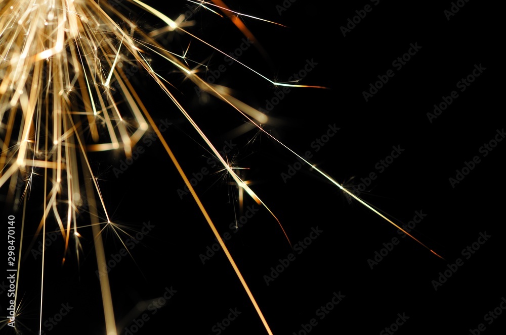 Fototapeta premium Close-up of golden sparkles of a burning fire