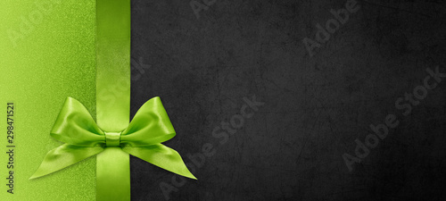 gift card wishes merry christmas background with green ribbon bow on black shiny vibrant color texture template with blank copy space