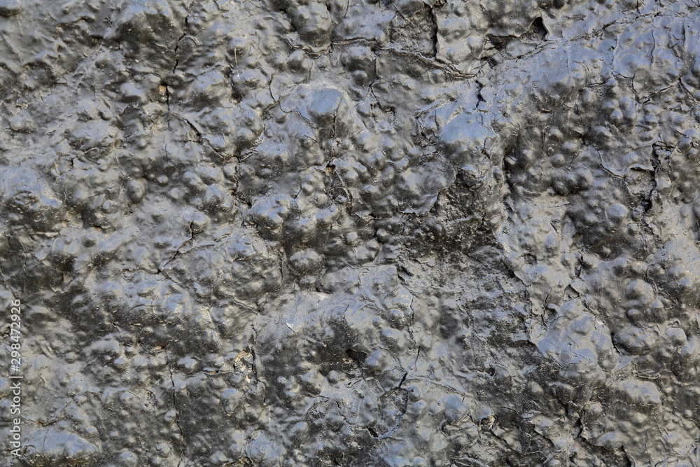 Black textured surface of volcanic lava as an element of design and decoration Black textured surface of volcanic lava as an element of design and decoration