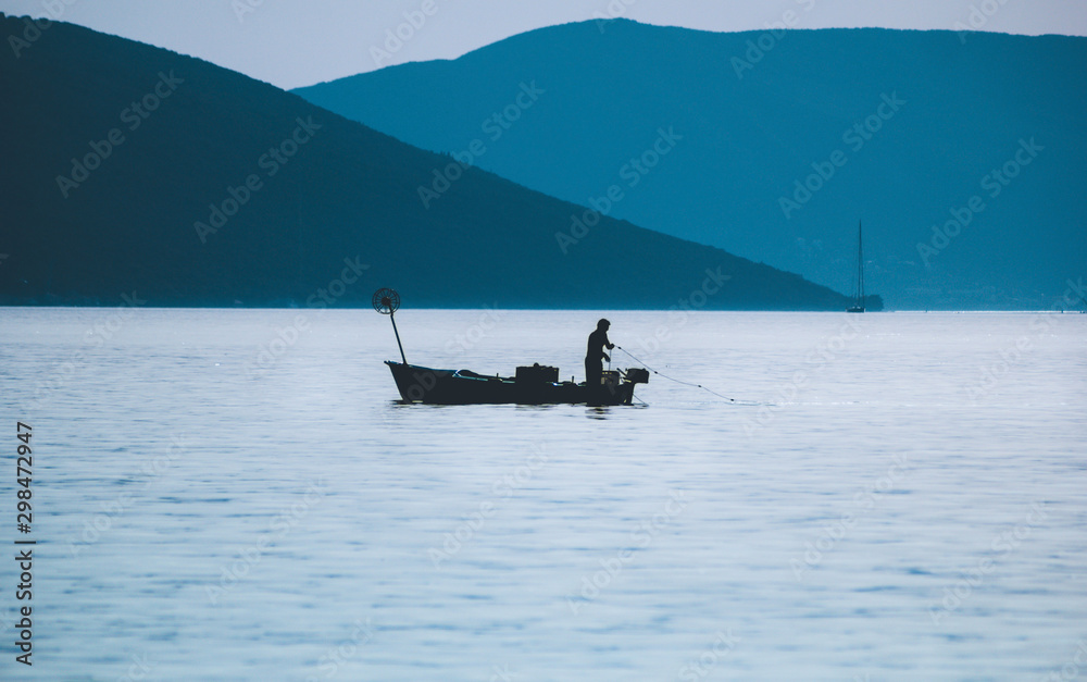 Silhouette of fisherman and boat at the sea Silhouette of fisherman and boat at the sea