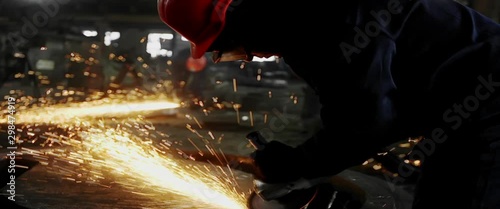 Male hand cuts off pieces of water pipe with angle grinder. Cutting of a steel with splashes of sparks at construction site. Sparks during cutting of metal angle grinder