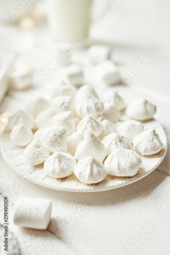 christmas meringue with marshmallows on a white background by the window