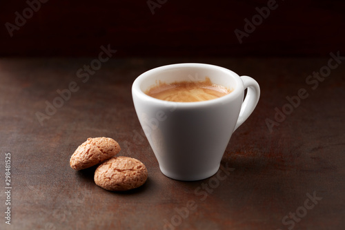 Cup of coffee with amaretti (Italian biscuits) on rustic wooden background. Copy space.