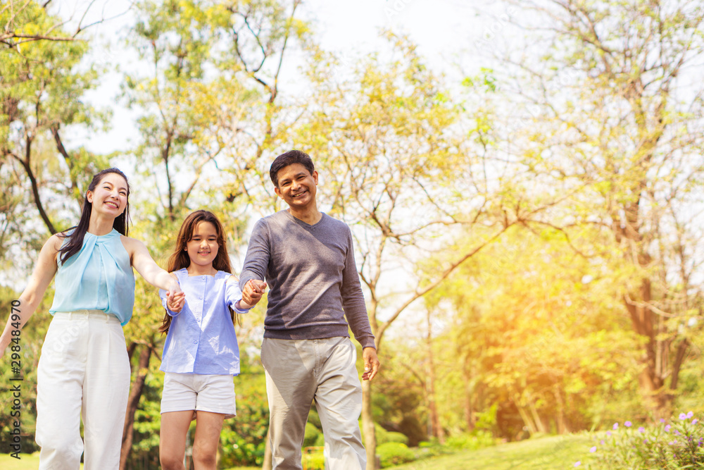 Parent families, children walking hand in hand happily in the park