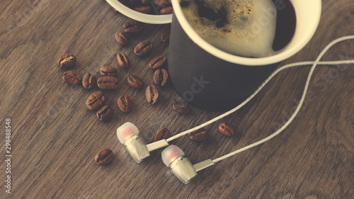 Coffee cup and headphones so close, vintage top view