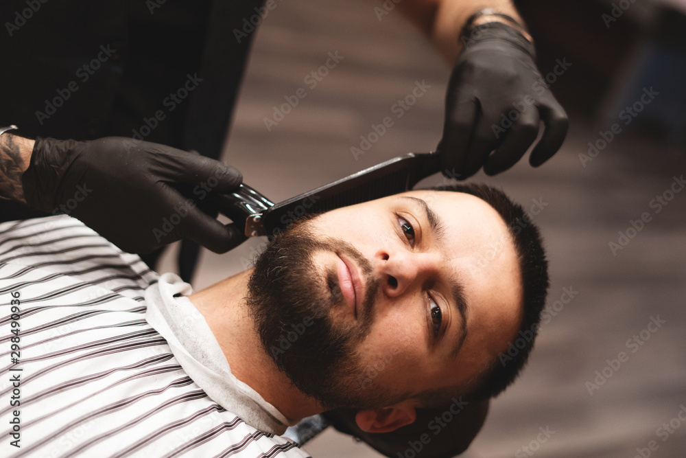 Shaving a beard in a barbershop with a dangerous razor. Barber Shop Beard Care. Drying, cutting, cutting a beard. Selective focus. Shaving a beard in a barbershop with a dangerous razor. Barber Shop Beard Care. Drying, cutting, cutting a beard. Selective focus.