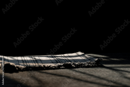 The wooden table by the window in kitchen with morning sunlight,Black background and tableware, selective focus.