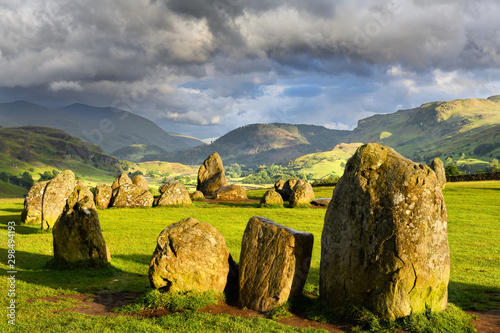 Konstfotografi Sun on Castlerigg Stone Circle under dark clouds on summer solstice eve with Nad