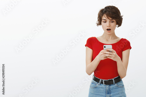 How could you post this picture. Shocked insulted concerned young girlfriend found photo ex girlfriend boyfriend smartphone drop jaw gasping surprised stare cellphone speechless white background photo