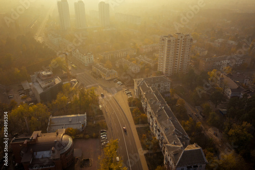 Strong atmospheric air pollution in the city. Environmental collapse with air. Thick yellow poisonous smog in the residential area of the city. Aerial photo from the drone.