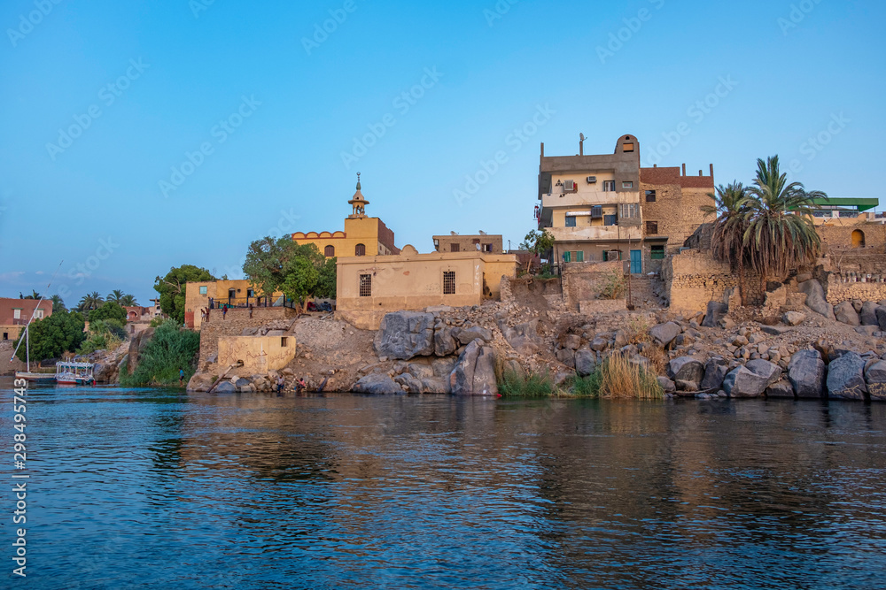 Houses and mosque on the bank of Nile river in Aswan, Egypt