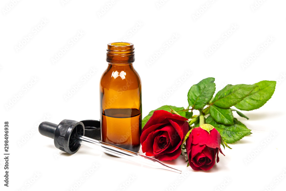 Rose oil in bottle and rose flower isolated on white background. Essential oil product concept. Rose oil in bottle and rose flower isolated on white background. Essential oil product concept.