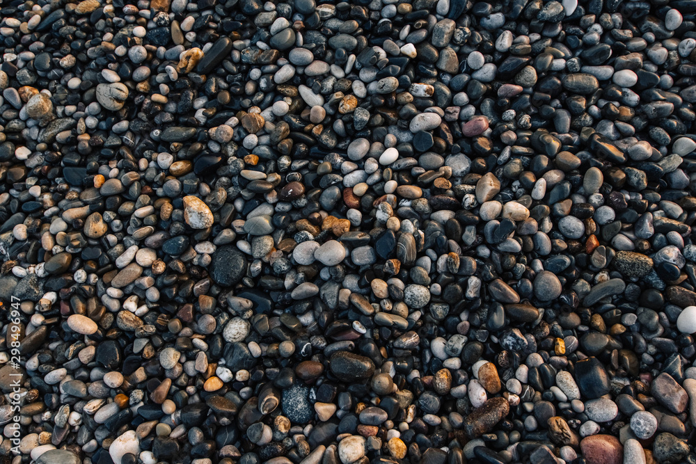 Gravel pattern of wet colored stones. Abstract nature pebbles background. Stone background. Sea peblles beach. Top view Gravel pattern of wet colored stones. Abstract nature pebbles background. Stone background. Sea peblles beach. Top view