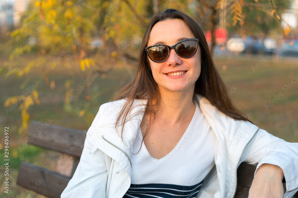 Beautiful middle-aged woman on a bench in the autumn park Beautiful middle-aged woman on a bench in the autumn park