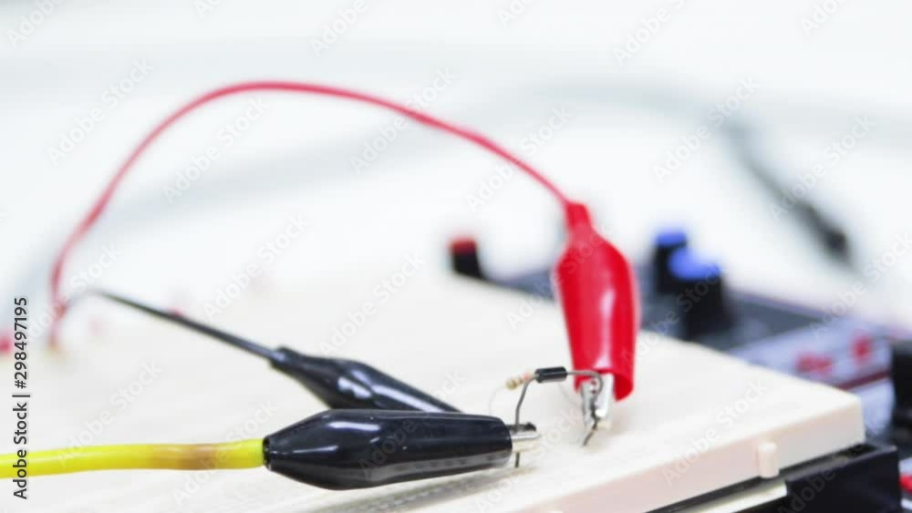 Engineering Student Connecting Oscilloscope Probe to a Resistor and Diode on Breadboard. Engineering Student Connecting Oscilloscope Probe to a Resistor and Diode on Breadboard.