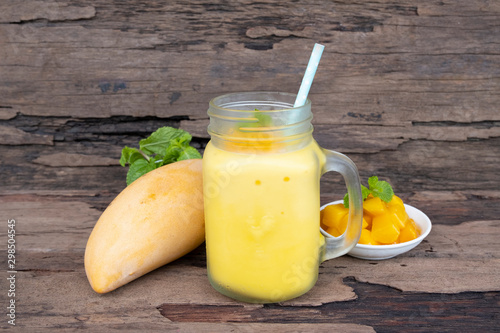 Mango smoothies yellow colorful fruit juice milkshake blend beverage healthy high protein the taste yummy In glass drink to lose weight drink episode morning on a wooden background.