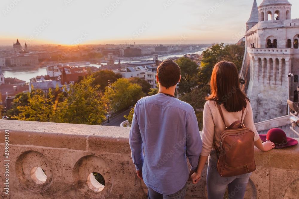 Naklejka premium Young couple enjoy the view from the point from Fisherman Bastion in Budapest during sunrise.