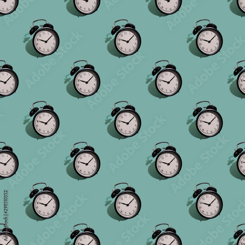 Schilderij op canvas Many black classic style alarm clock with hard shadow isolated on green background