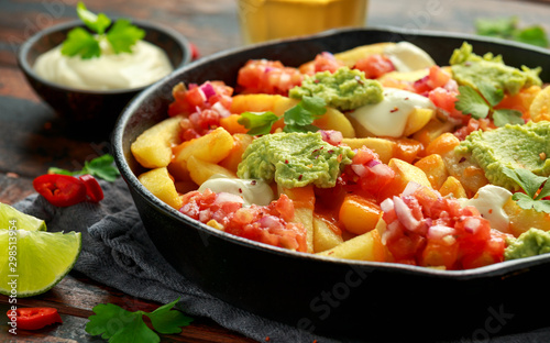 Loaded potato nachos with melted cheddar cheese, sour cream, tomato salsa, chilli, guacamole and beer