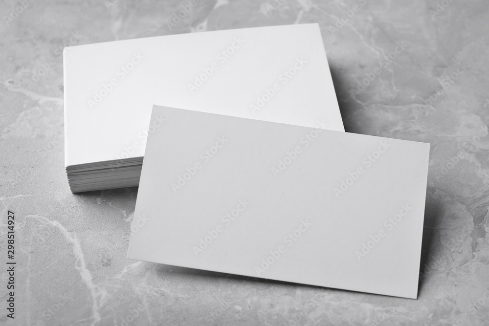 Stack of empty sheets on grey marble table. Mock up for design - obrazy, fototapety, plakaty 
