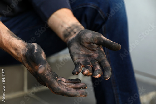 Dirty worker sitting on stairs, closeup of hands © New Africa