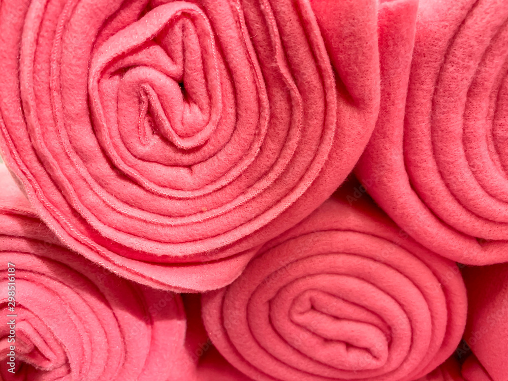 Fototapeta premium Many rolled up pink colorful fleece blankets close up in a store, home comfort concept