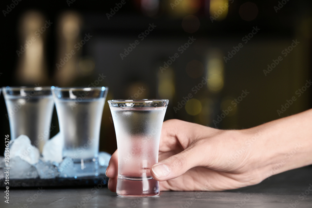 Woman with shot of vodka at table in bar, closeup Woman with shot of vodka at table in bar, closeup