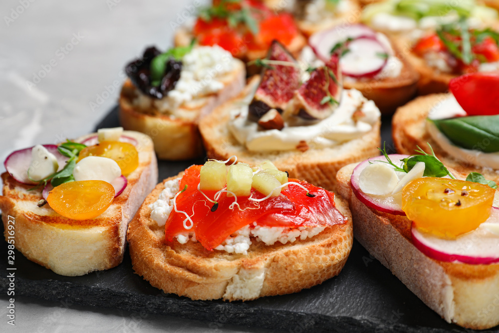 Different bruschettas on light grey marble table, closeup