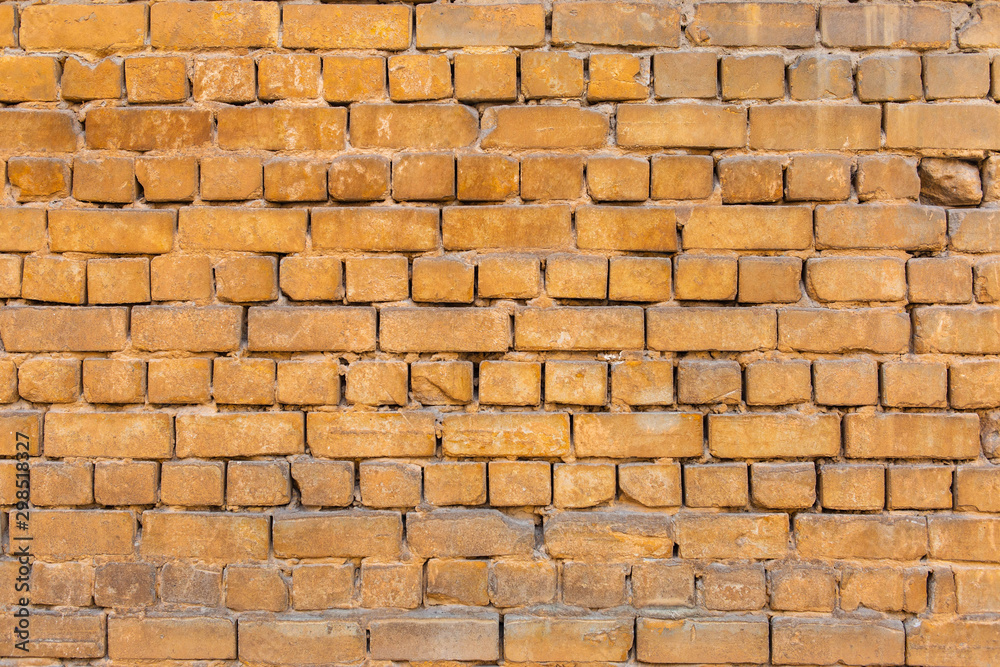 Naklejka premium texture of an old yellow brick wall