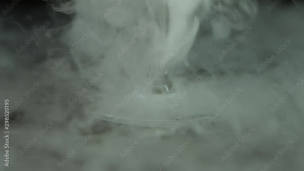 Glass leg on a black surface with falling smoke on it. Close up. Slow motion Glass leg on a black surface with falling smoke on it. Close up. Slow motion