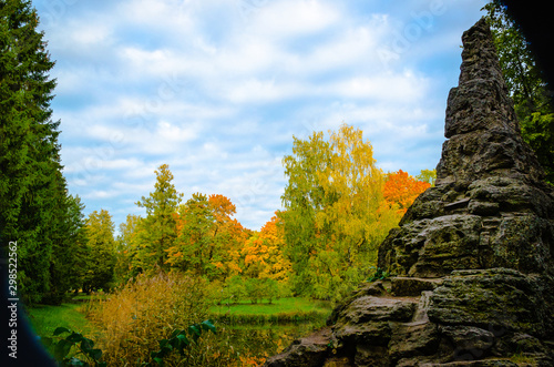 Autumn landscape in the Park with a stone rock against a cloudy sky.