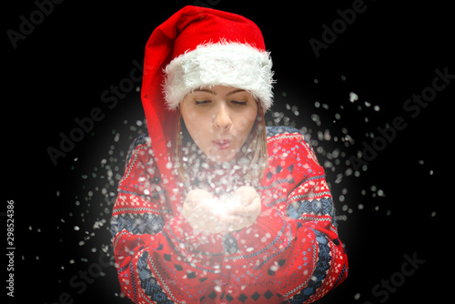 An isolated shot of a woman celebrating christmas and blowing snow