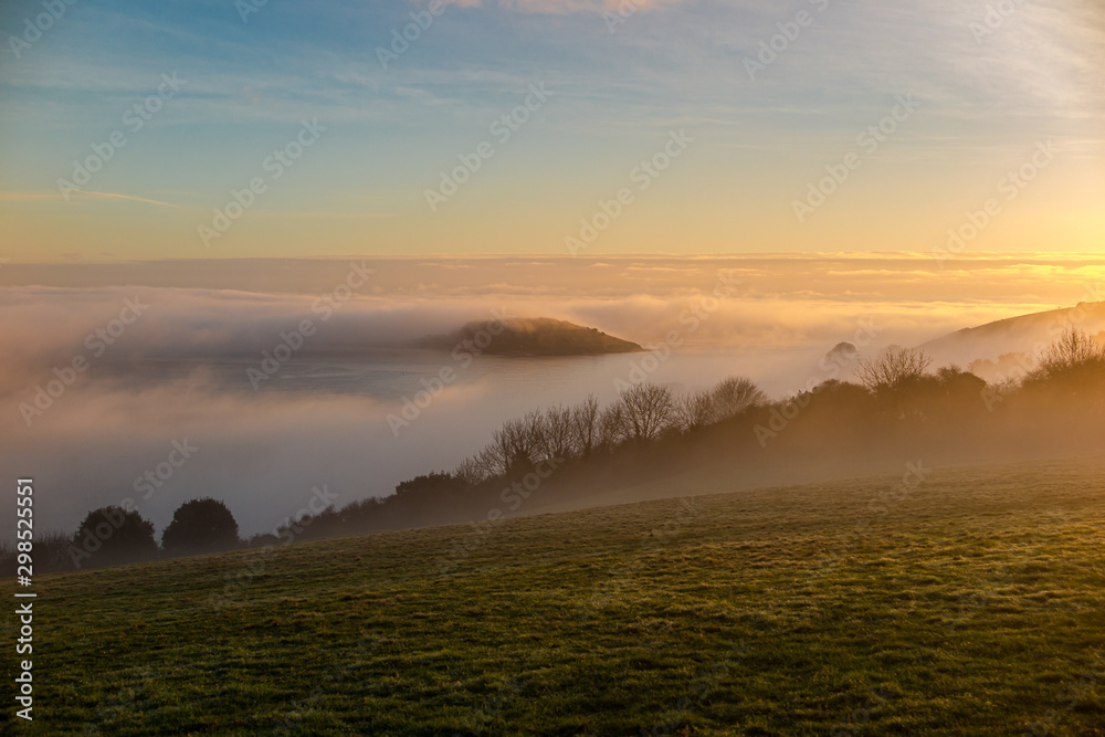land mist flowing out to sea in whitsand bay Cornwall land mist flowing out to sea in whitsand bay Cornwall
