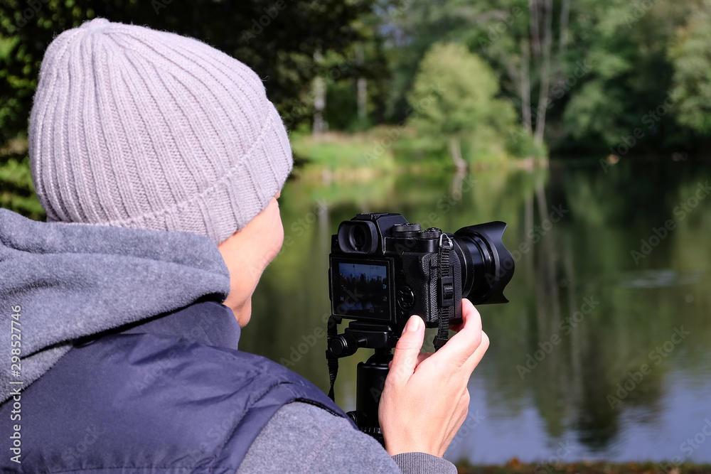 Obraz premium Girl photographer. The tripod with the camera.