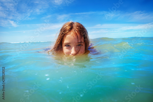 Half underwater portrait of a girl swim in the sea © Sergey Novikov