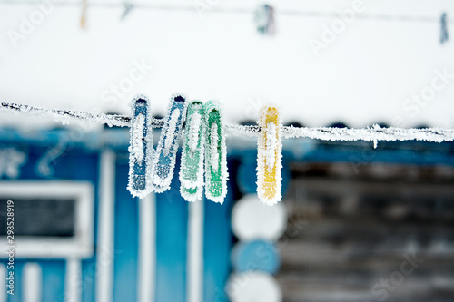 frozen icy snow-covered clothespins outside in winter  low temperatures