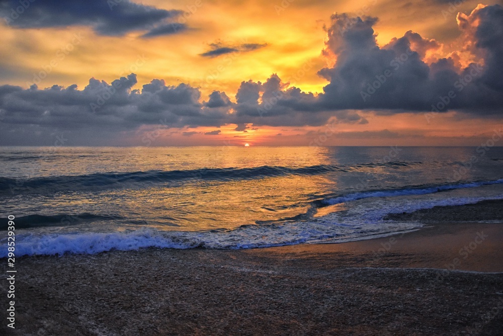 Phuket beach sunset, colorful cloudy twilight sky reflecting on the sand gazing at the Indian Ocean, Thailand, Asia. Phuket beach sunset, colorful cloudy twilight sky reflecting on the sand gazing at the Indian Ocean, Thailand, Asia.