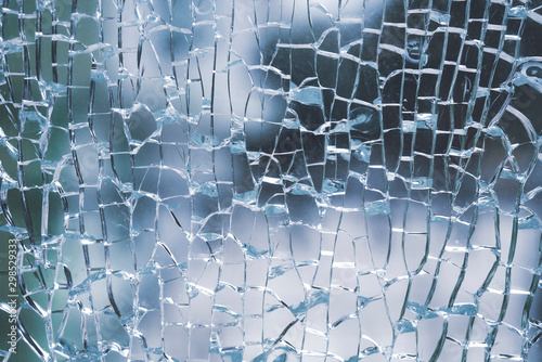 Abstract background of cobweb cracks The texture of the broken cracks. Close-up of a cracked glass. Dirty scratched broken glass of a office door
